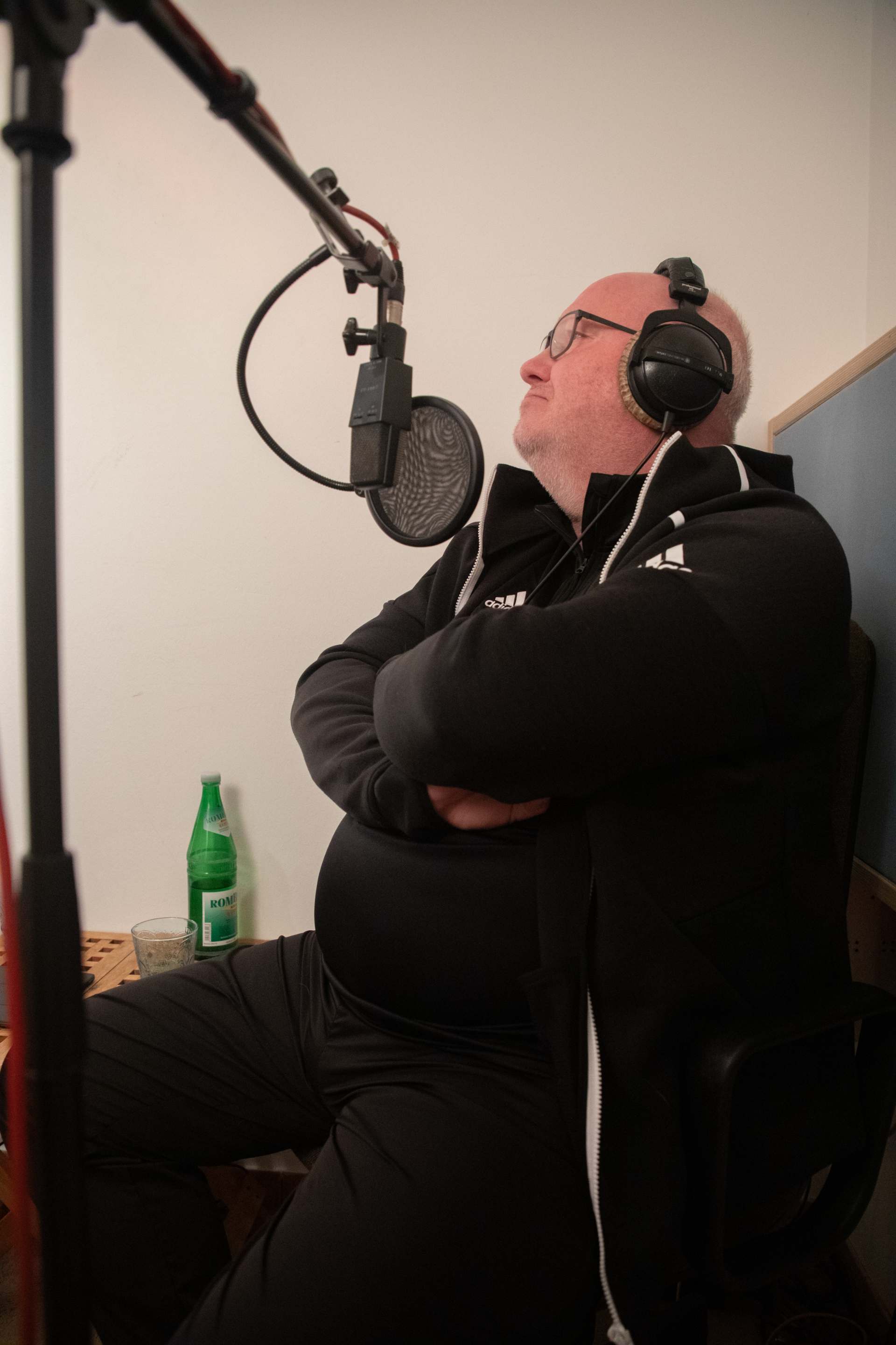 Mann im Tonstudio mit Mikrofon und Kopfhörern 

