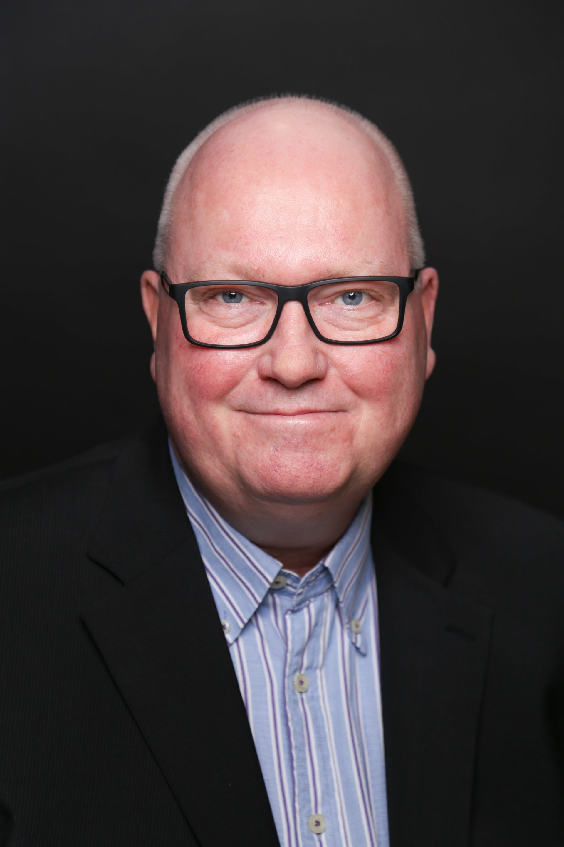 Mann mit Brille und Hemd in Portraitansicht
